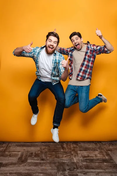 Retrato de comprimento total de dois jovens felizes celebrando — Fotografia de Stock