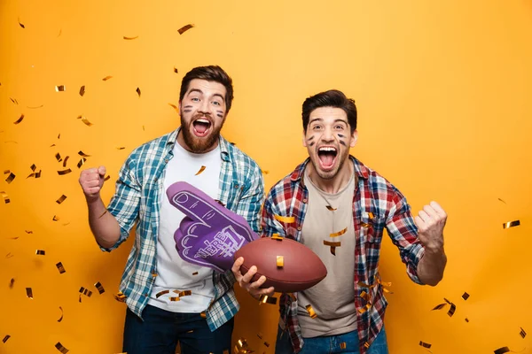 Portrait of a two excited young men holding rugby ball — Stock Photo, Image