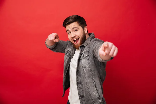 Joyful bearded man 30s in jeans jacket looking on camera with po — Stock Photo, Image