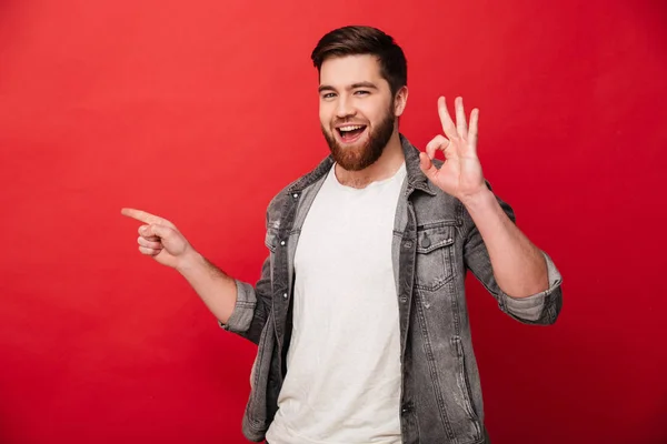 Photo of content brunette man 30s in jeans jacket showing ok sig — Stock Photo, Image