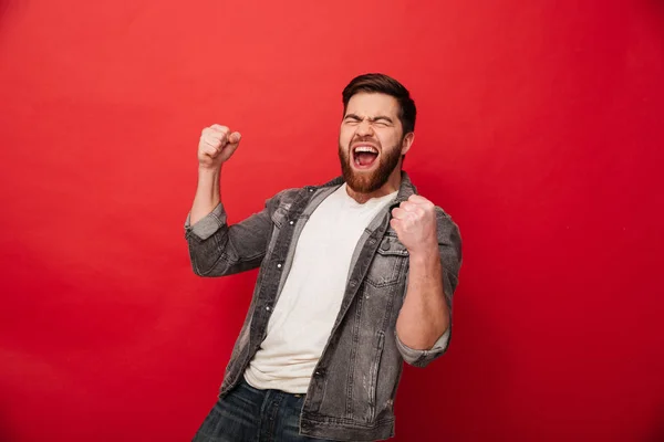 Photo of ecstatic cheerful man 30s in jeans jacket yelling in de