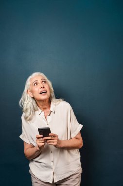 Cep telefonu kullaranarak olgun yaşlı kadın.
