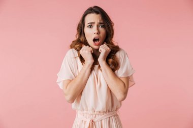 Kameraya bakarak elbiseli korkmuş bir genç kız portresi