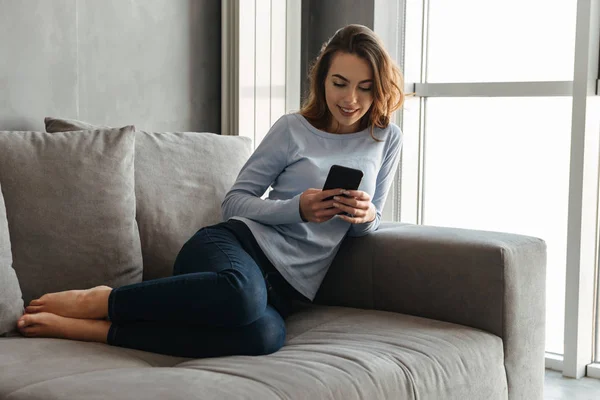 Portrait of a happy young woman using mobile phone — Stock Photo, Image