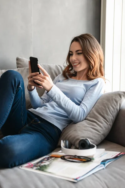 Portrait of a happy young woman using mobile phone — Stock Photo, Image