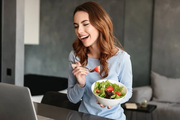 Retrato de una joven alegre comiendo ensalada fresca — Foto de Stock