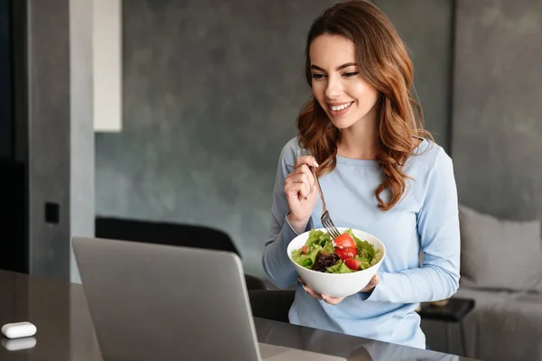 Retrato de uma jovem mulher bonita comendo salada fresca — Fotografia de Stock