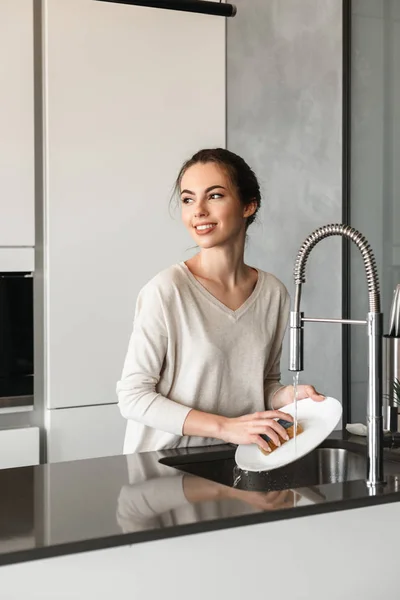Портрет веселой молодой женщины, моющей посуду — стоковое фото