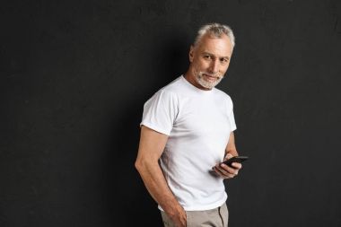 Mutlu yakışıklı olgun yaşlı cep telefonu kullanan adam.