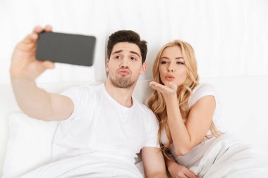 Genç sevgili çift selfie tarafından telefonla yapmak.