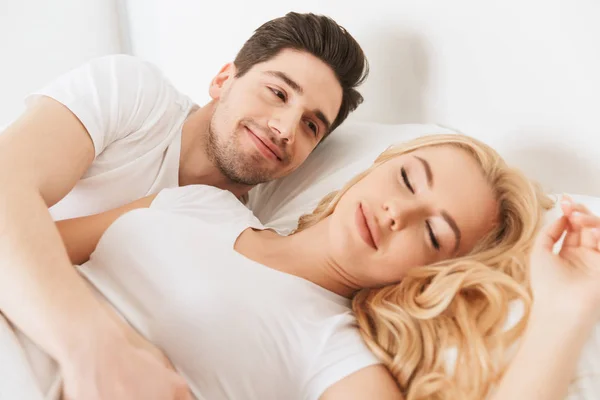 Mann legt seine nahe Ehefrau schlafend ins Bett — Stockfoto