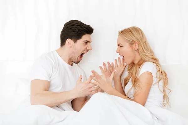 Young displeased loving couple in bed — Stock Photo, Image