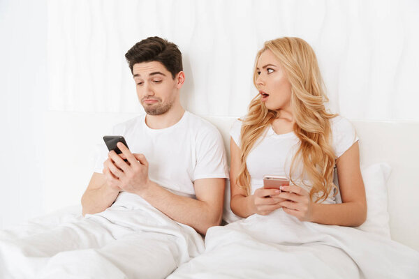 Modern young couple using mobile phones