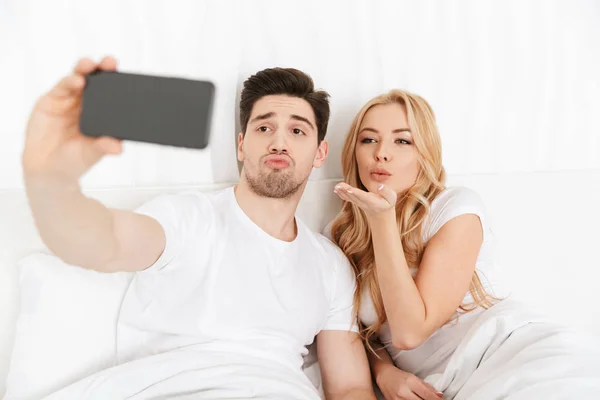 Весела молода закохана пара робить селфі по телефону — стокове фото