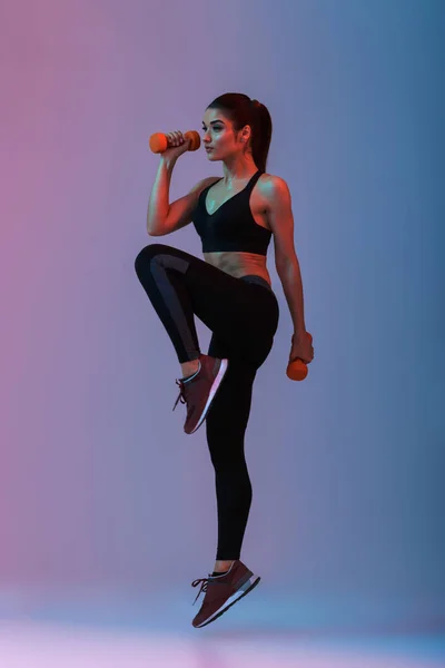 Полнометражный портрет спортсменки в спортивном костюме, делающей упражнения — стоковое фото