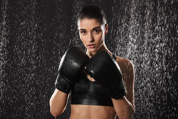 Строга жінка займається спортом і боксу в рукавичках, стоячи в — стокове фото