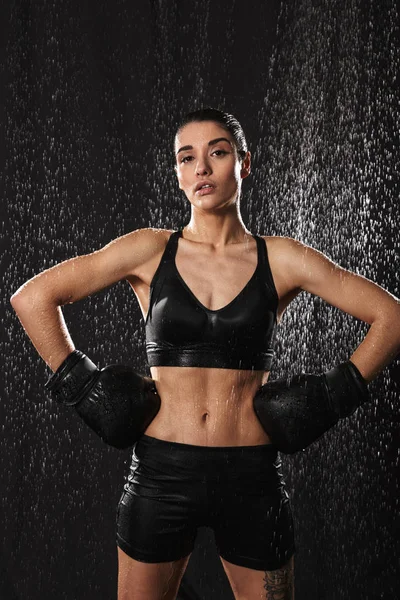 Wet sexual woman putting arms in boxing gloves on waist and look — Stock Photo, Image