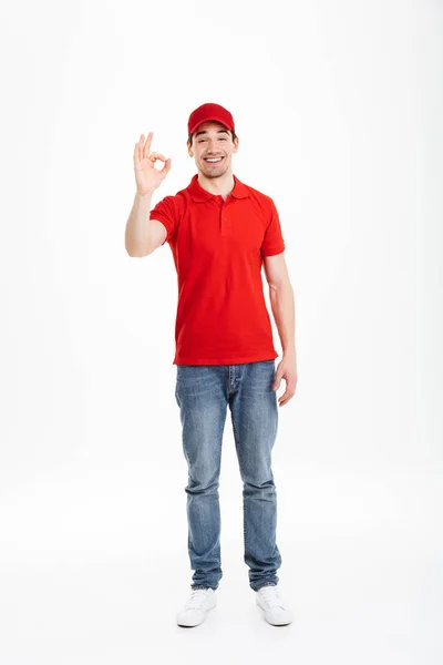 Smiling young delivery man with okay gesture — Stock Photo, Image