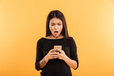 Cep telefonu kullaranarak memnun şok genç kadın.