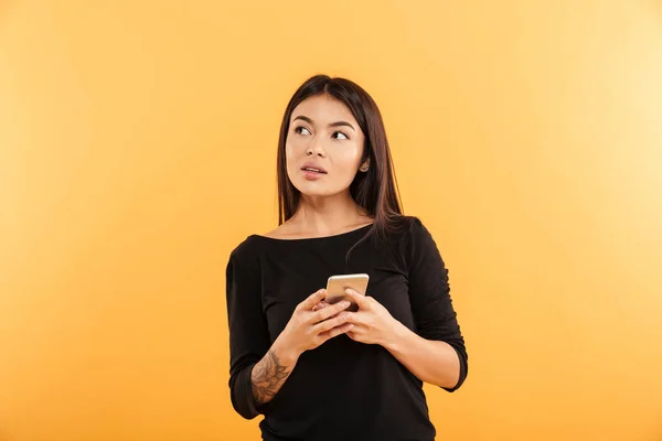 Pensando en una mujer joven usando el teléfono móvil . — Foto de Stock