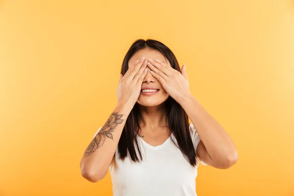 Cheerful young woman covering eyes with hands. — Stock Photo, Image