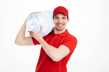 Görüntü gülümseyen, şişelenmiş su dağıtım kurye kırmızı t-shirt içinde bir