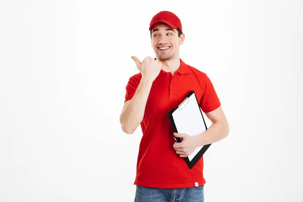 젊은 택배 남자 빨간 t-셔츠와 모자 웃 고 fi를 가리키는 — 스톡 사진