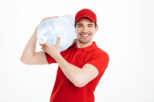 Imagem do correio de entrega de água engarrafada sorridente na t-shirt vermelha a — Fotografia de Stock