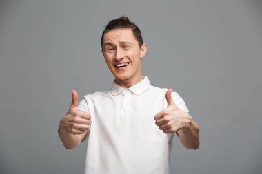 başparmak gösterilen mutlu bir genç adam.