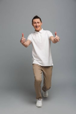 başparmak gösterilen mutlu bir genç adam.