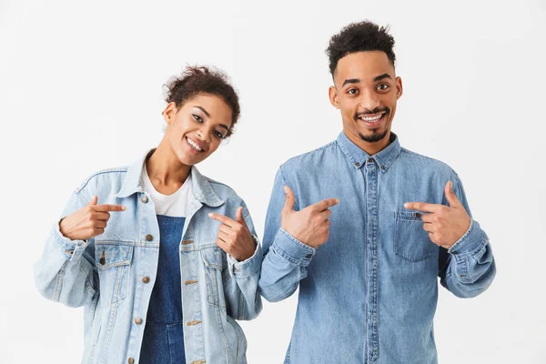 Усміхнена африканська пара в джинсових сорочках вказує на себе — стокове фото