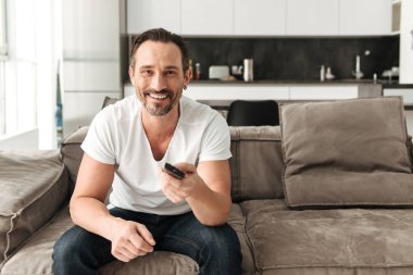 Kanepede oturan gülümseyen olgun adam