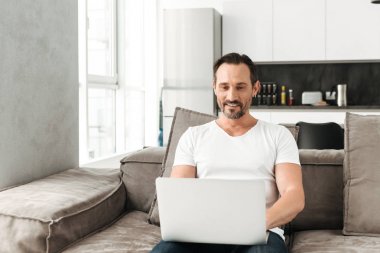 Kanepede oturan gülümseyen olgun adam