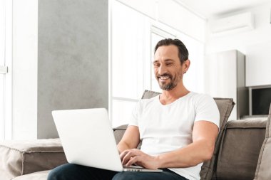 Kanepede oturan mutlu olgun adam