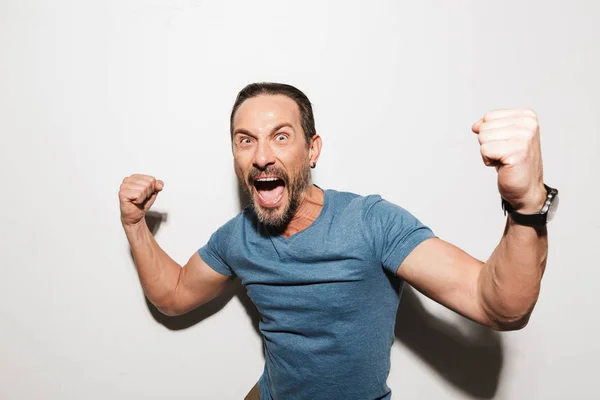 Portrait of a happy mature man dressed in t-shirt celebrating — Stock Photo, Image