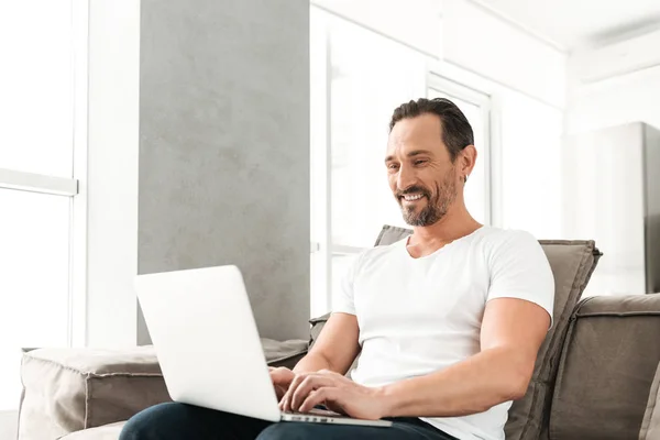 Gelukkig volwassen man zittend op een bank — Stockfoto