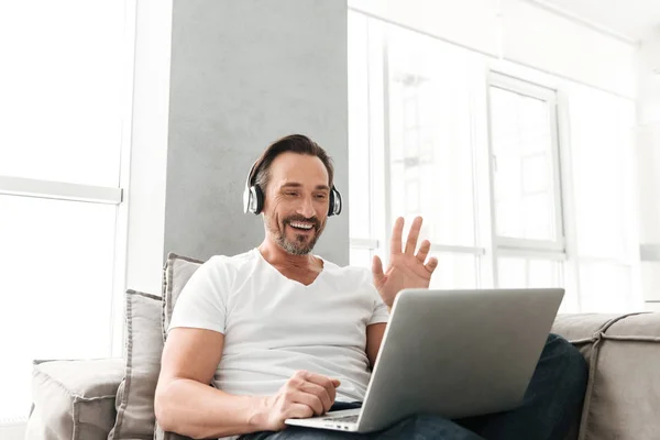 Lächelnder älterer Mann, der mit Kopfhörern Musik hört — Stockfoto