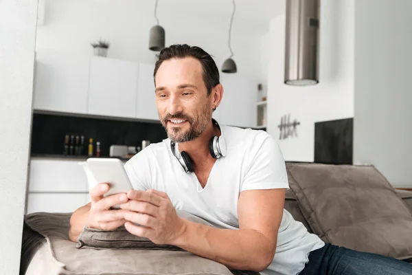 Handsome mature man holding mobile phone — Stock Photo, Image