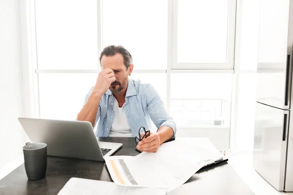 Tired mature man working with documents — Stock Photo, Image