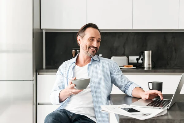 Sonriendo hombre maduro teniendo desayuno saludable —  Fotos de Stock