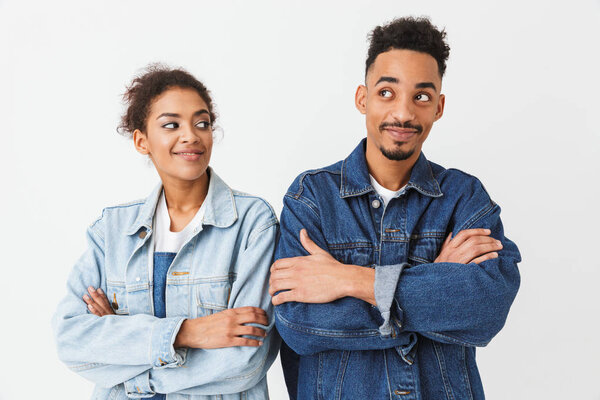 Счастливая пара в джинсовых рубашках позирует вместе со скрещенными руками
