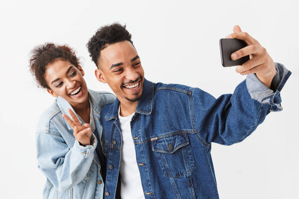 Улыбающаяся африканская пара в джинсовых рубашках веселится вместе

