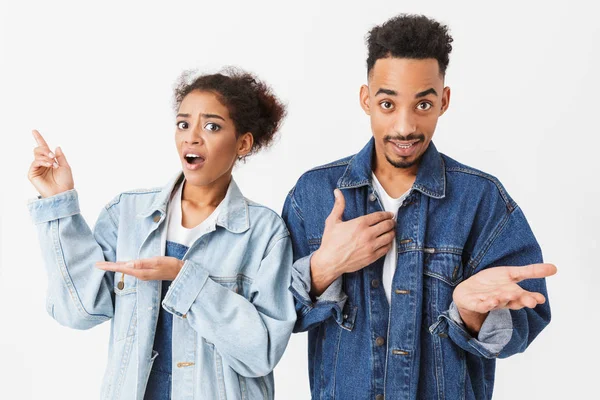 Förvånad förvirrad afrikanska par i denim skjortor tittar på kameran — Stockfoto