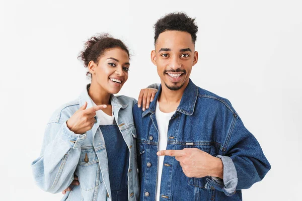 Веселая африканская пара в джинсовых рубашках, указывающая друг на друга — стоковое фото