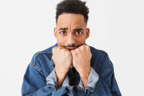 Worried african man in denim jacket covering mouth with fists — Stock Photo, Image