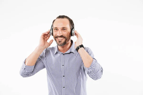 Przystojny, uśmiechnięty człowiek dorosły słuchania muzyki ze słuchawkami — Zdjęcie stockowe
