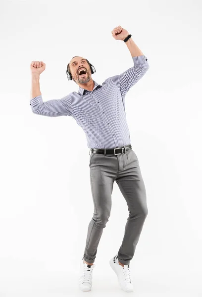 Handsome cheerful adult man listening music dancing — Stock Photo, Image