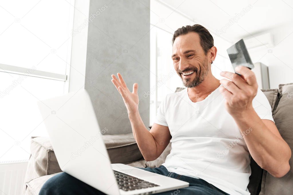 Satisfied mature man using laptop computer