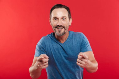 İyimser adam 30'lu rahat t-shirt gülümseyen ve pointi görüntüsünü