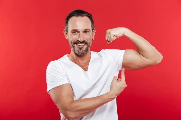 Hombre adulto sonriente mostrando bíceps . — Foto de Stock